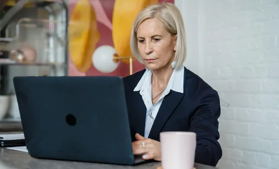 Mid-career professional editing a document at a desk.